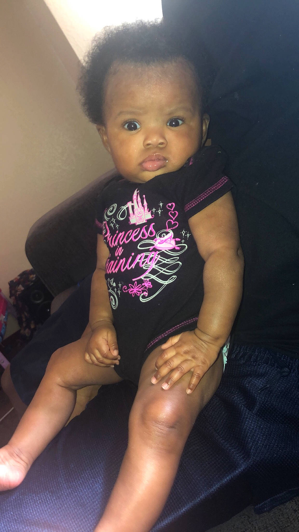 Aaniyah is registered to the contest to win money with this photo: arm, baby, cheek, child, face, finger, hand, head, human_leg, joint, knee, leg, muscle, person, pink, sitting, skin, sportswear, thigh, thumb