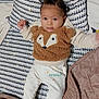 baby, bed, blanket, child, clothing, cute, expression, face, footed_pants, hair, indoors, infant, lying_down, pants, patterned_bedding, person, sleepwear, small_hands, soft_toys_design, sweater