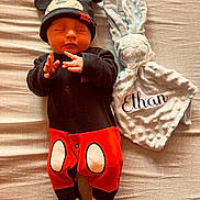 Ethan a rejoint le concours — aidez-le/la à gagner de superbes lots ! baby, sleeping, mickey_mouse_hat, onesie, plush_bunny, blanket, bed, infant, cozy, cute, lying_down, hands, feet, soft_toy, portrait, newborn, fabric_texture, nursery_item, props, warm_lighting