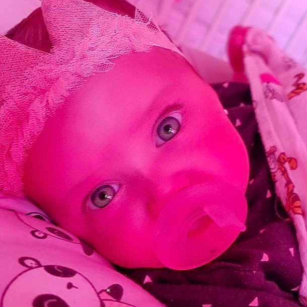 Pietra is registered to the contest to win money with this photo: baby, baby_toddler_clothing, cheek, eye, eyebrow, eyelash, happy, head, headgear, human_body, iris, lip, mouth, nose, pink, purple, skin, toddler, violet, white