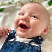 Timéo a rejoint le concours — aidez-le/la à gagner de superbes lots ! baby, smiling, denim_overalls, white_shirt, infant, closeup, face, happy, cute, child, skin, eyes, hand, portrait, young, fabric, button, casual_clothing, indoor, soft_light