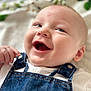 baby, smiling, denim_overalls, white_shirt, infant, closeup, face, happy, cute, child, skin, eyes, hand, portrait, young, fabric, button, casual_clothing, indoor, soft_light
