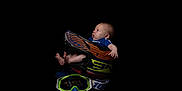 Timéo participe au concours pour gagner de l'argent avec cette photo : baby, barefoot, black_background, blue_clothing, bright_colors, child, curious_expression, face, goggles, helmet, infant, isolated, motocross, person, portrait, protective_gear, side_view, small_feet, sports_equipment, studio_shot