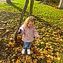 Lily Rose is registered to the contest to win money with this photo: child, toddler, autumn, leaves, tree, grass, outdoor, toy, ghost_toy, jacket, curly_hair, white_shoes, jeans, sunlight, building, stone, window, pathway, nature, playful