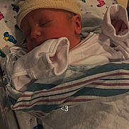 Ares is registered to the contest to win money with this photo: architecture, baby, bed, blanket, building, cap, clothing, crib, face, furniture, glove, hat, head, hospital, newborn, person, photography, portrait, quilt, sleeping