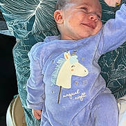 Lana participe au concours pour gagner de l'argent avec cette photo : baby, infant, smiling, onesie, purple_clothing, unicorn, pillow, car_interior, seat, patterned, child, cute, happy, lying_down, soft_toys, cozy, newborn, face, portrait, relaxed