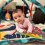 Lana a rejoint le concours — aidez-le/la à gagner de superbes lots ! baby, blanket, child, colorful, curious, cushion, cute, eyes, face, hands, hanging_toy, indoors, infant, living_room, pink_clothing, play_mat, portrait, soft_toys, toy, young