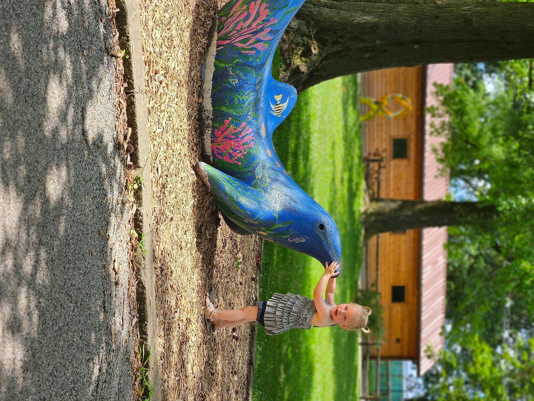 Miah is registered to the contest to win money with this photo: art, beak, bird, bird_supply, electric_blue, feather, grass, human_leg, leisure, macaw, metal, parrot, person, plant, sculpture, tail, tree, trunk, wheel, wing