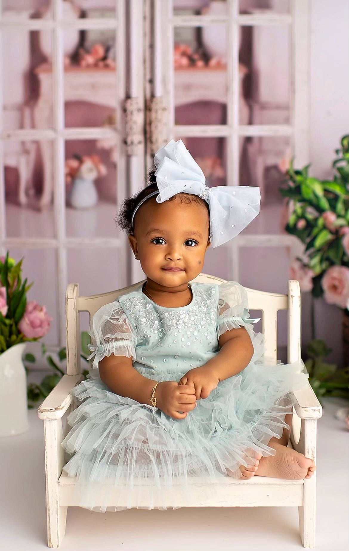 Kalani is registered to the contest to win money with this photo: cake_decorating, child, dress, event, fashion_accessory, formal_wear, happy, headgear, headpiece, jewellery, peach, person, petal, pink, plant, rectangle, room, sitting, sweetness, toddler