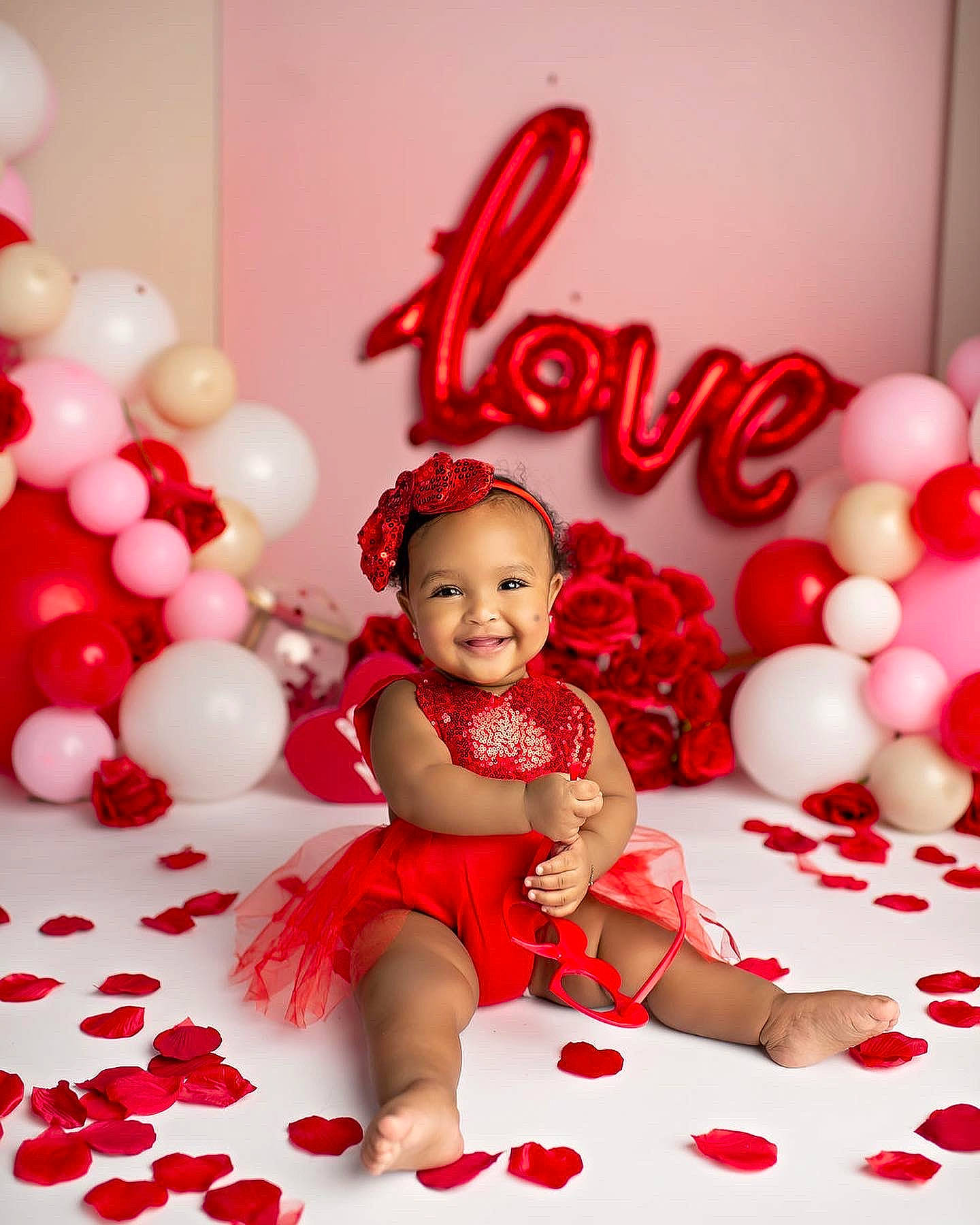 Kalani is registered to the contest to win money with this photo: arm, baby_toddler_clothing, balloon, beauty, child, facial_expression, font, happy, human_body, joy, magenta, party_supply, people, person, photograph, pink, red, smile, sweetness, textile