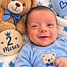 Jacob is registered to the contest to win money with this photo: baby, newborn, infant, smiling, portrait, close_up, face, blue_clothing, teddy_bear, plush_toy, blanket, stars, heart, milestone, two_months, wooden_sign, indoor, lying_down, cute, family_photo