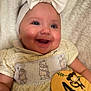 Darcie is registered to the contest to win money with this photo: baby, smiling, headband, bow, dress, yellow, bear_embroidery, wooden_sign, monkey, 4_months, milestone, child, happy, cute, portrait, infant, hand, skin, closeup, indoor