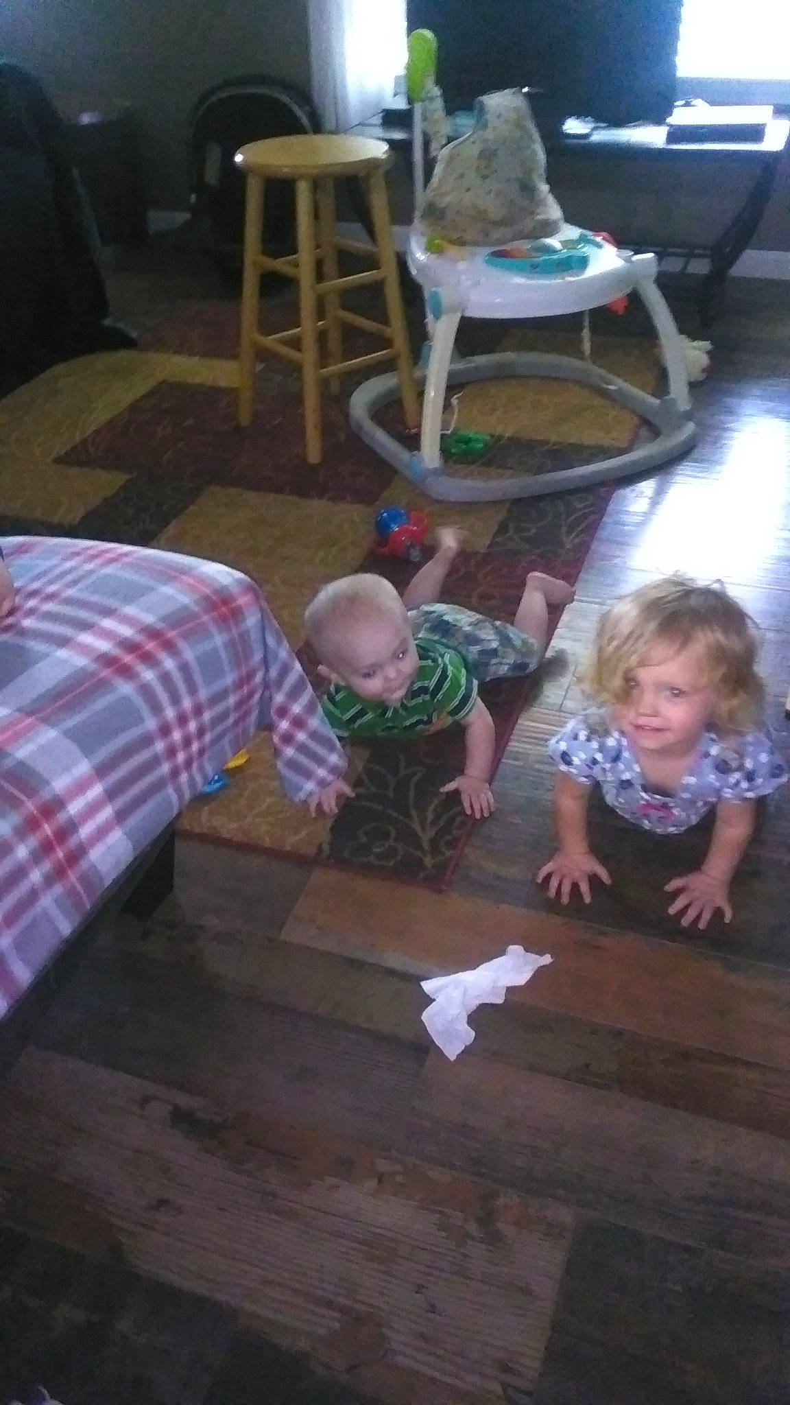 Eliza is registered to the contest to win money with this photo: baby, chair, child, comfort, event, floor, flooring, fun, hardwood, holiday, lap, leisure, living_room, person, plaid, room, sitting, t_shirt, tartan, toddler