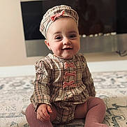 Yana is registered to the contest to win money with this photo: baby, child, smile, plaid, hat, knee_socks, pink, sitting, indoor, carpet, cute, portrait, face, apparel, young_child, fashion, adorable, candid, infant, happy