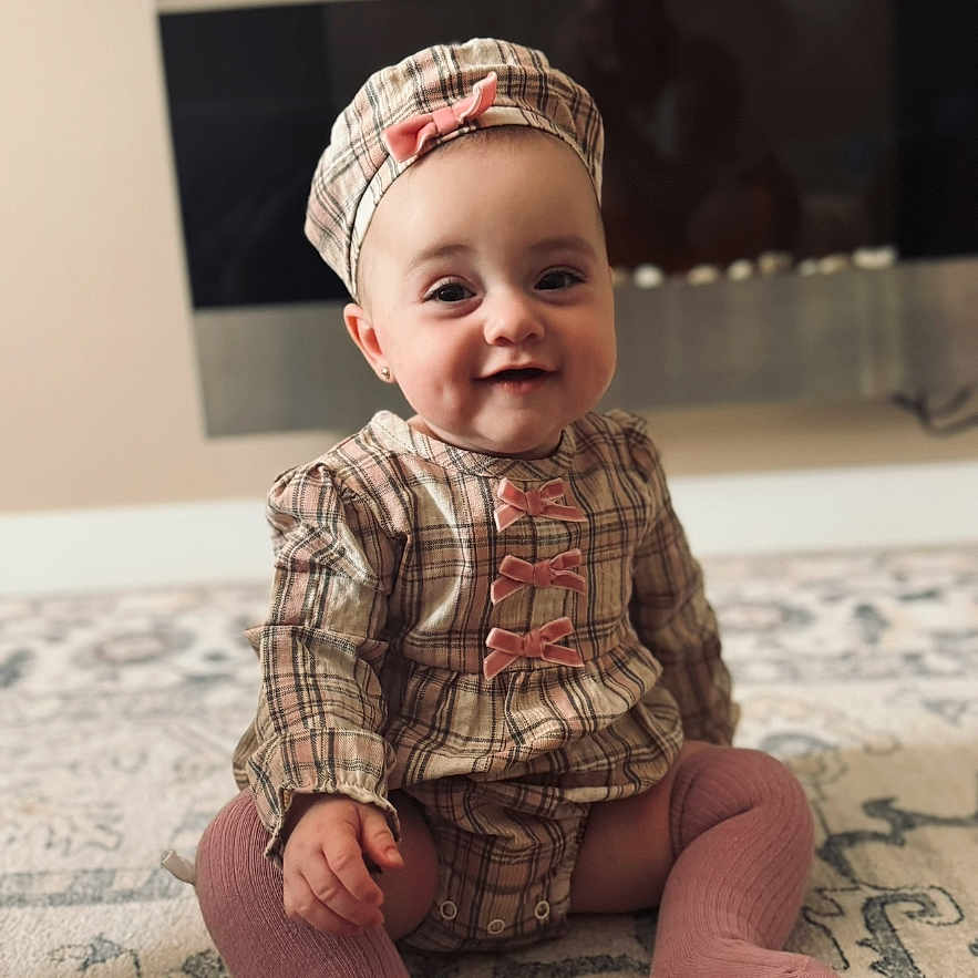 Yana is registered to the contest to win money with this photo: adorable, apparel, baby, candid, carpet, child, cute, face, fashion, happy, hat, indoor, infant, knee_socks, pink, plaid, portrait, sitting, smile, young_child