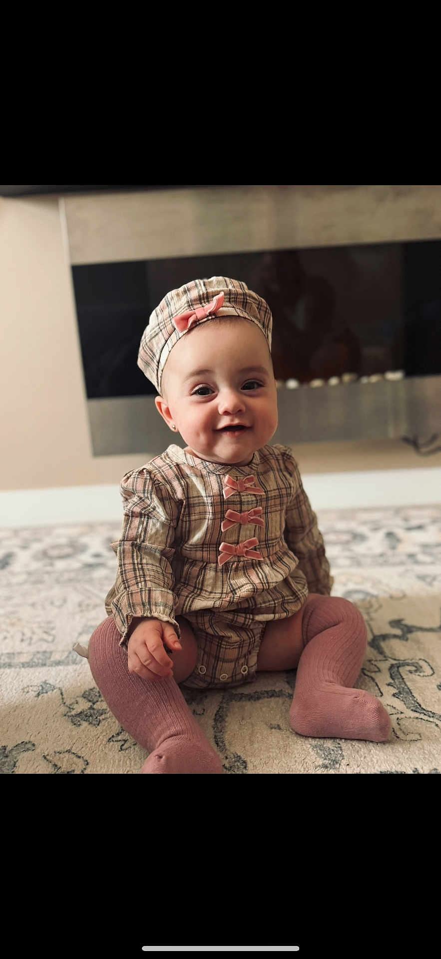 Yana is registered to the contest to win money with this photo: baby, child, smile, plaid, hat, knee_socks, pink, sitting, indoor, carpet, cute, portrait, face, apparel, young_child, fashion, adorable, candid, infant, happy