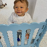 Lygan a rejoint le concours — aidez-le/la à gagner de superbes lots ! background_child, blue_gate, child, clothing, daycare, eyes, face, furniture, hair, hand, happy, indoor, playpen, playroom, polka_dot_floor, shoe, smile, standing, toddler, toy