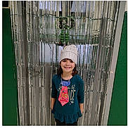 Selena joined the competition — help win amazing prizes! celebration, child, costume, decoration, door, event, girl, green_wall, happy, holiday, indoors, long_sleeve_shirt, paper_crown, person, portrait, school, smiling, standing, streamers, tie