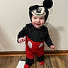 Samuel joined the competition — help win amazing prizes! toddler, child, costume, mickey_mouse, smile, indoor, floor, wooden_floor, red_clothing, black_clothing, headwear, cute, standing, happy, person, baby, wall, sock, playful, portrait