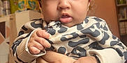 Ajooni is registered to the contest to win money with this photo: baby, child, red_bow, headband, leopard_print, clothing, hands, tattoos, bracelet, indoor, room, person, face, cute, curious, infant, holding, black_hair, portrait, expression