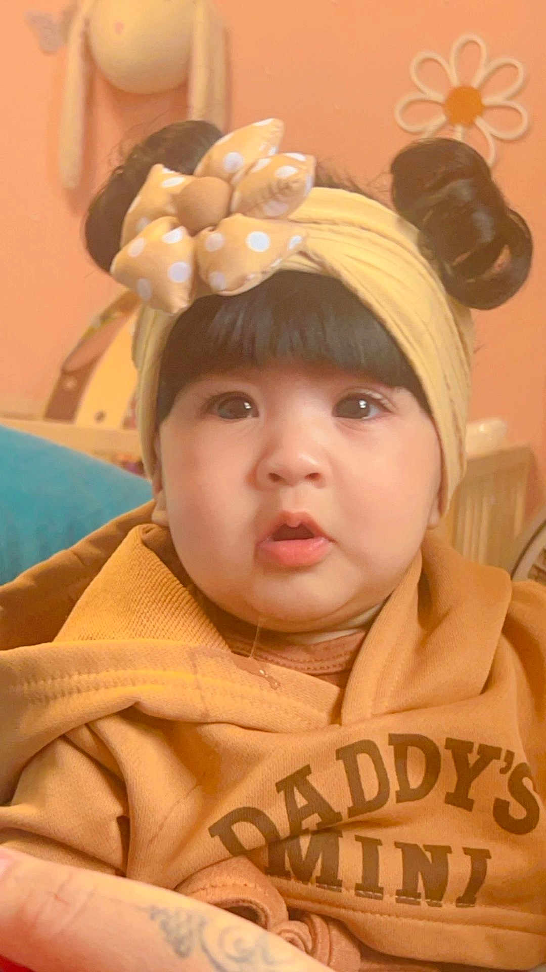 Ajooni joined the competition — help win amazing prizes! baby, child, headband, bow, hoodie, clothing, face, portrait, indoors, cute, childhood, expression, curly_hair, soft_lighting, warm_colors, person, infant, young_child, cozy, adorable