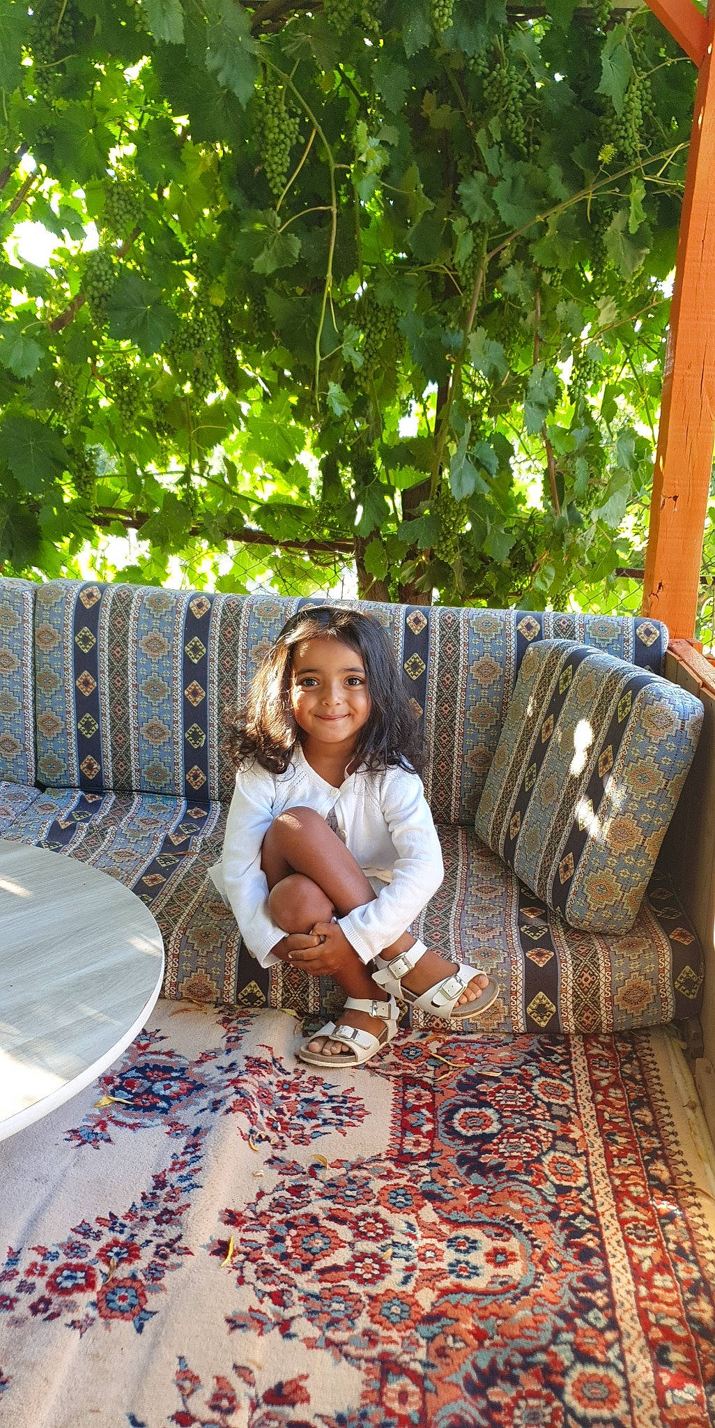 Mona participe au concours pour gagner de l'argent avec cette photo : bag, carpet, flooring, fun, grass, joy, leaf, leisure, linens, luggage_and_bags, outdoor_furniture, pattern, person, plaid, recreation, room, sitting, smile, tablecloth, toddler