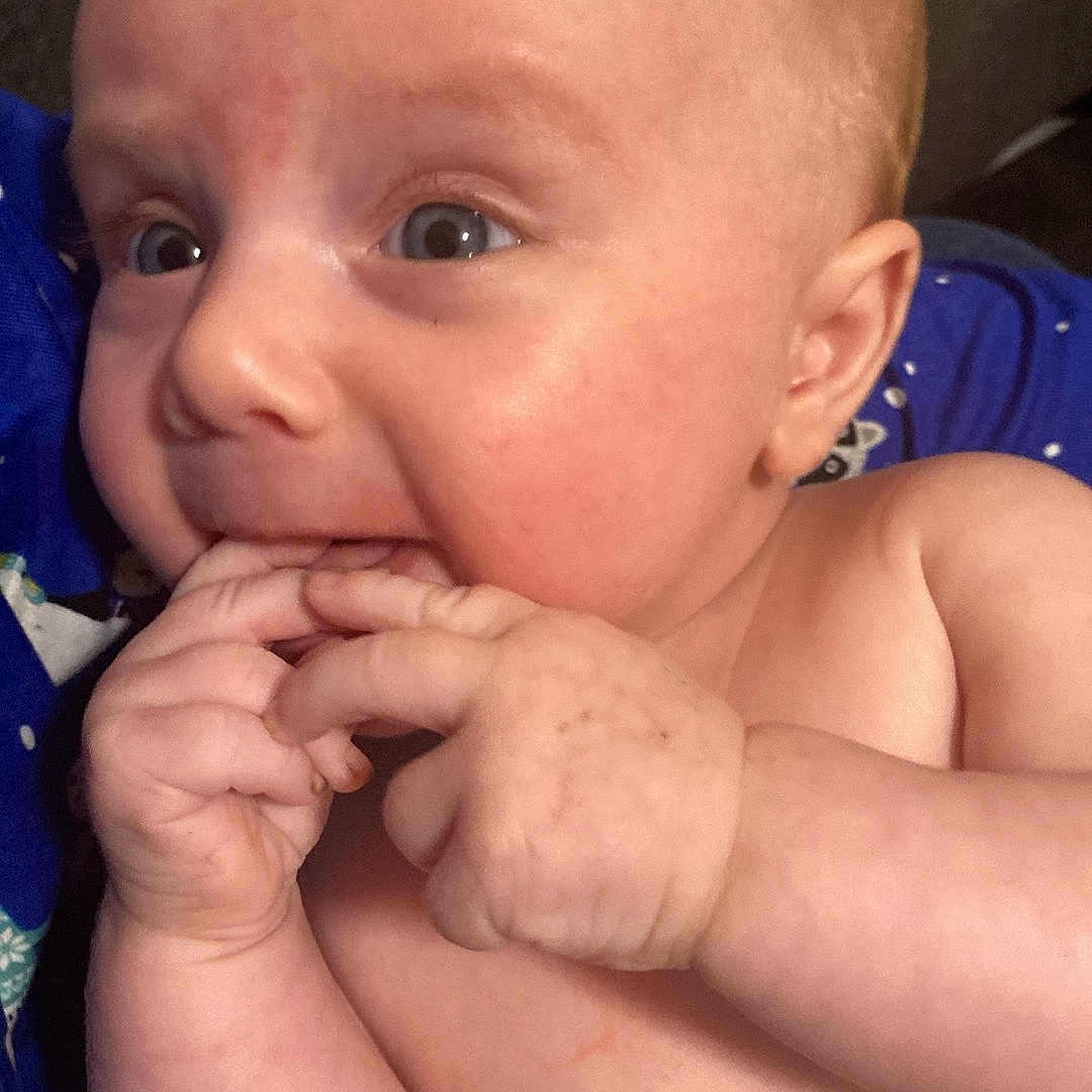 Benjamin May is registered to the contest to win money with this photo: baby, blue_clothing, cheeks, child, closeup, curious, cute, expression, eyes, face, fingers, hand, human, indoor, infant, pattern, portrait, resting, skin, young