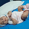 Doralynn is registered to the contest to win money with this photo: baby, infant, bed, pillow, blue_bed_sheet, pink_socks, headband, bunny_ears, cute, clothing, lying_down, indoors, child, portrait, soft_texture, playful, newborn, person, sleepwear, cozy