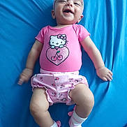 Doralynn joined the competition — help win amazing prizes! baby, pink_clothing, headband, bow, hello_kitty, smiling, lying_down, blue_background, socks, child, infant, cute, happy, playful, portrait, indoor, watermark, text_overlay, legs, arms