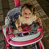 Brianna is registered to the contest to win money with this photo: toddler, baby_walker, child, toy, steering_wheel, outdoor, night, stone_path, playtime, motion_blur, joyful, pink, white, clothing, person, seat, hand, footwear, sidewalk, happy