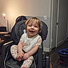 baby, child, high_chair, smiling, indoor, lamp, door, floor, dog, wood_floor, clothing, bib, hands, feet, face, person, happy, seat, light, home