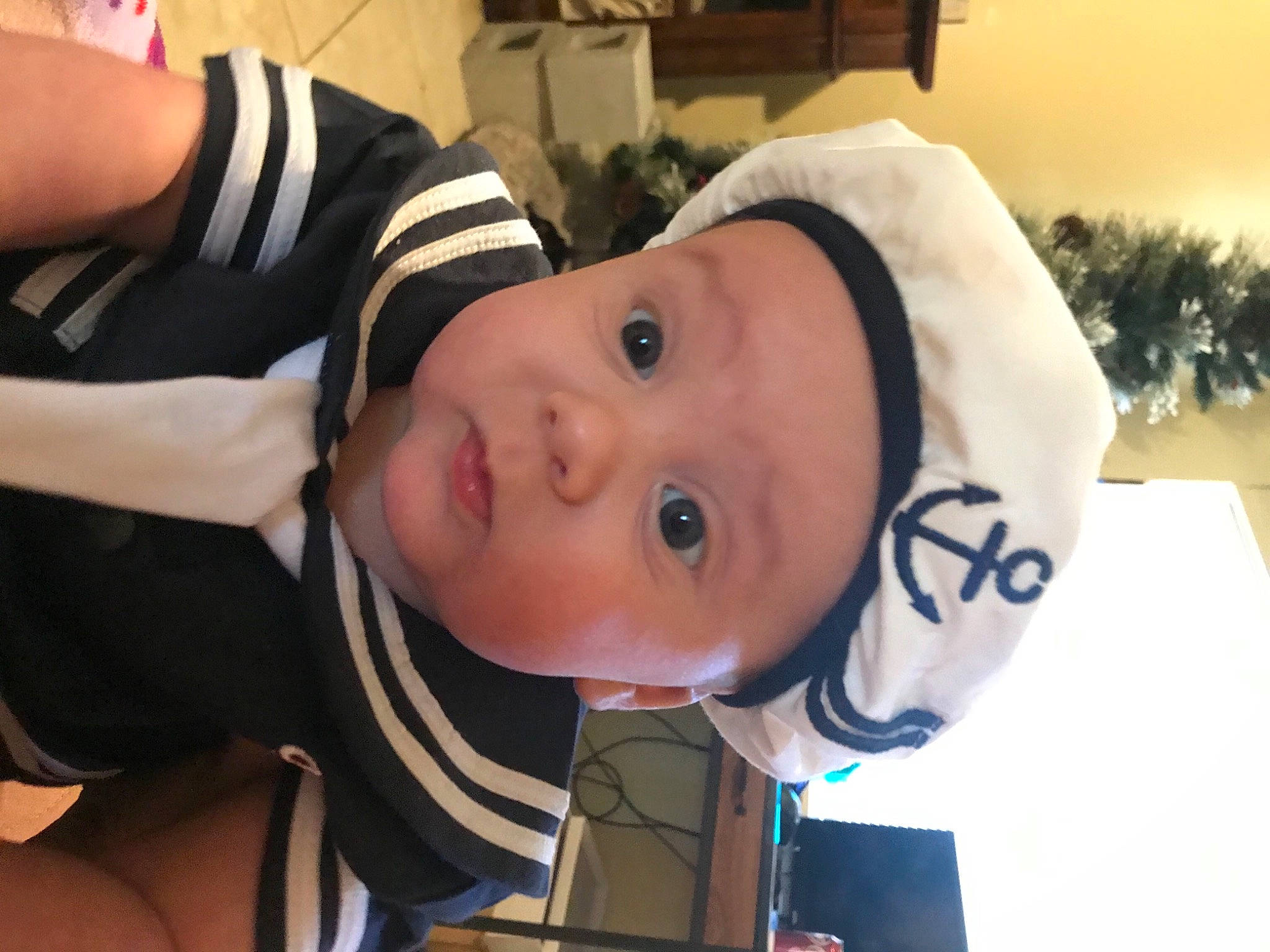 Sawyer is registered to the contest to win money with this photo: baby, baby_toddler_clothing, cheek, child, elbow, eyebrow, eyelash, fun, hat, headgear, headwear, lip, mouth, nose, person, personal_protective_equipment, plant, room, surprise, toddler