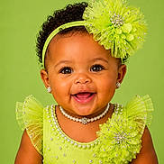 Maci is registered to the contest to win money with this photo: baby, child, portrait, smiling, curly_hair, headband, pearl_necklace, earrings, green_dress, tulle, decorative_flower, close_up, happy, cute, studio_photo, fashion, accessories, infant, bright_background, joyful