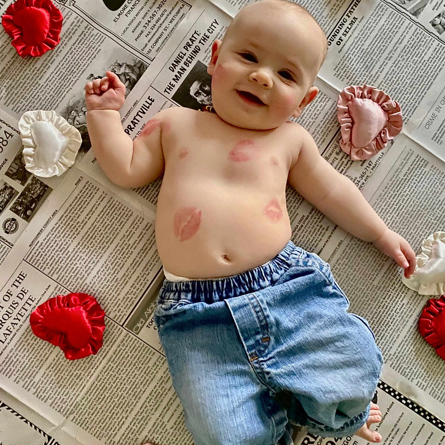 Copeland joined the competition — help win amazing prizes! baby, bare_chest, child, cute, denim_pants, floor, foot, hand, happy, head, heart_cushions, indoor, infant, kisses, lipstick_marks, lying_down, newspaper, skin, smiling, soft_toys
