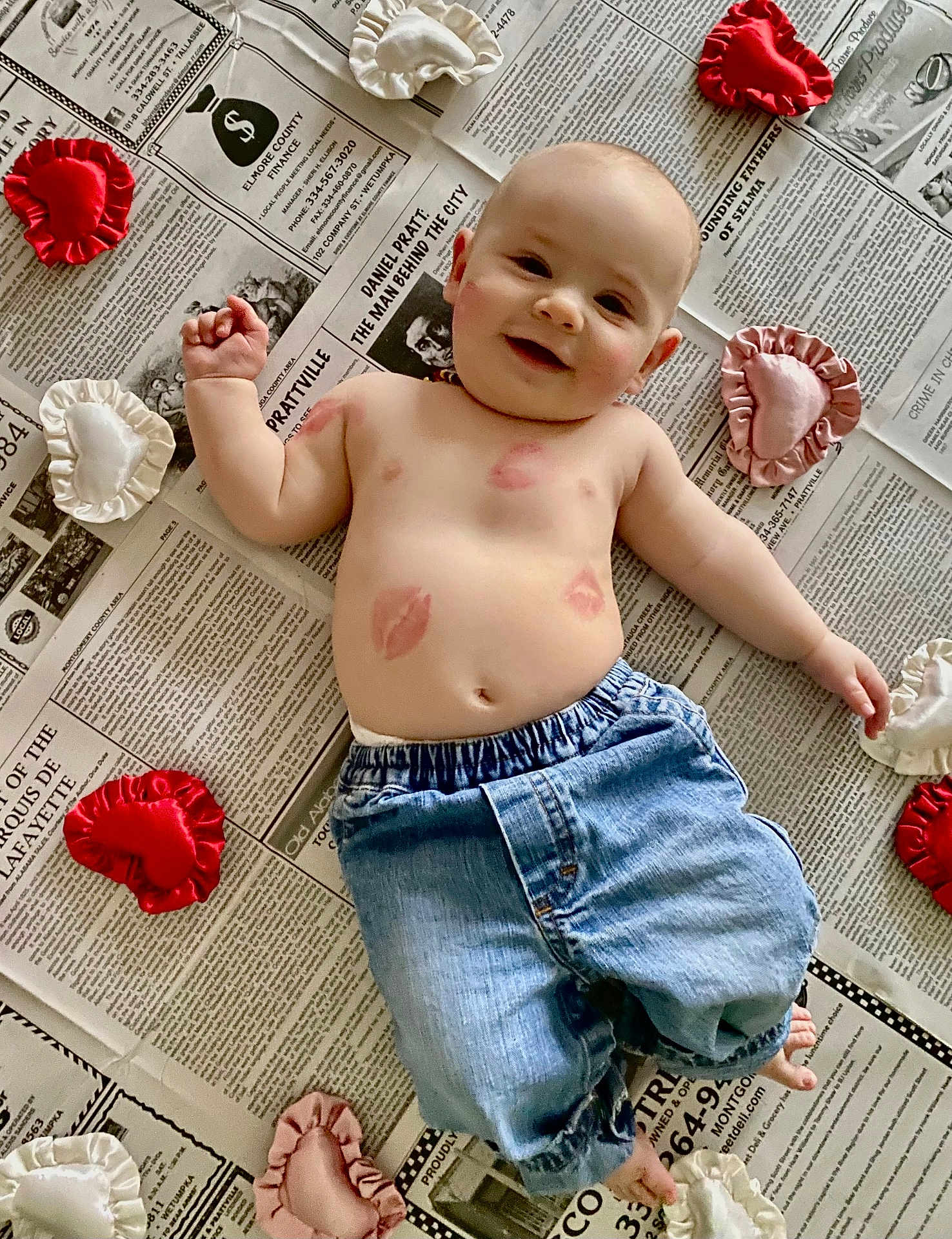 Copeland joined the competition — help win amazing prizes! baby, bare_chest, child, cute, denim_pants, floor, foot, hand, happy, head, heart_cushions, indoor, infant, kisses, lipstick_marks, lying_down, newspaper, skin, smiling, soft_toys