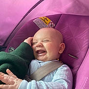 Copeland is registered to the contest to win money with this photo: baby, laughing, car_seat, purple, child, smiling, infant, seatbelt, hand, clothing, person, cute, happy, indoor, face, head, sleeve, child_seat, safety, joy
