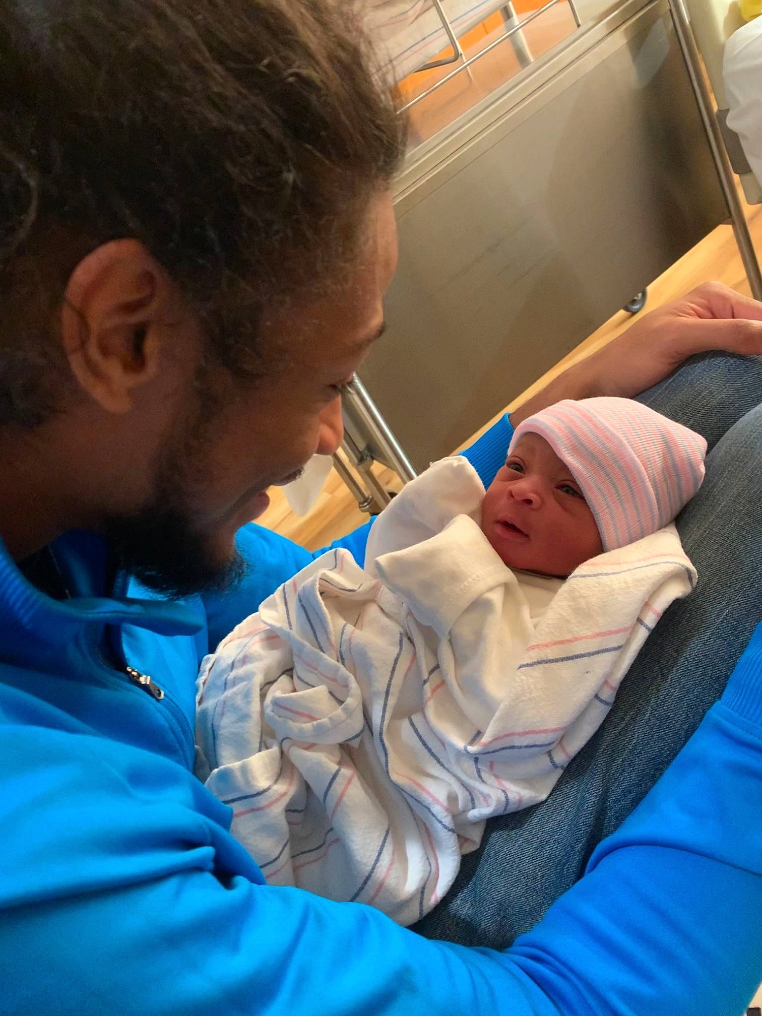 Jaylani is registered to the contest to win money with this photo: baby, baby_products, child, comfort, event, hat, headwear, health_care, hospital, hospital_bed, human, medical, medical_procedure, mouth, patient, person, room, science, service, sitting