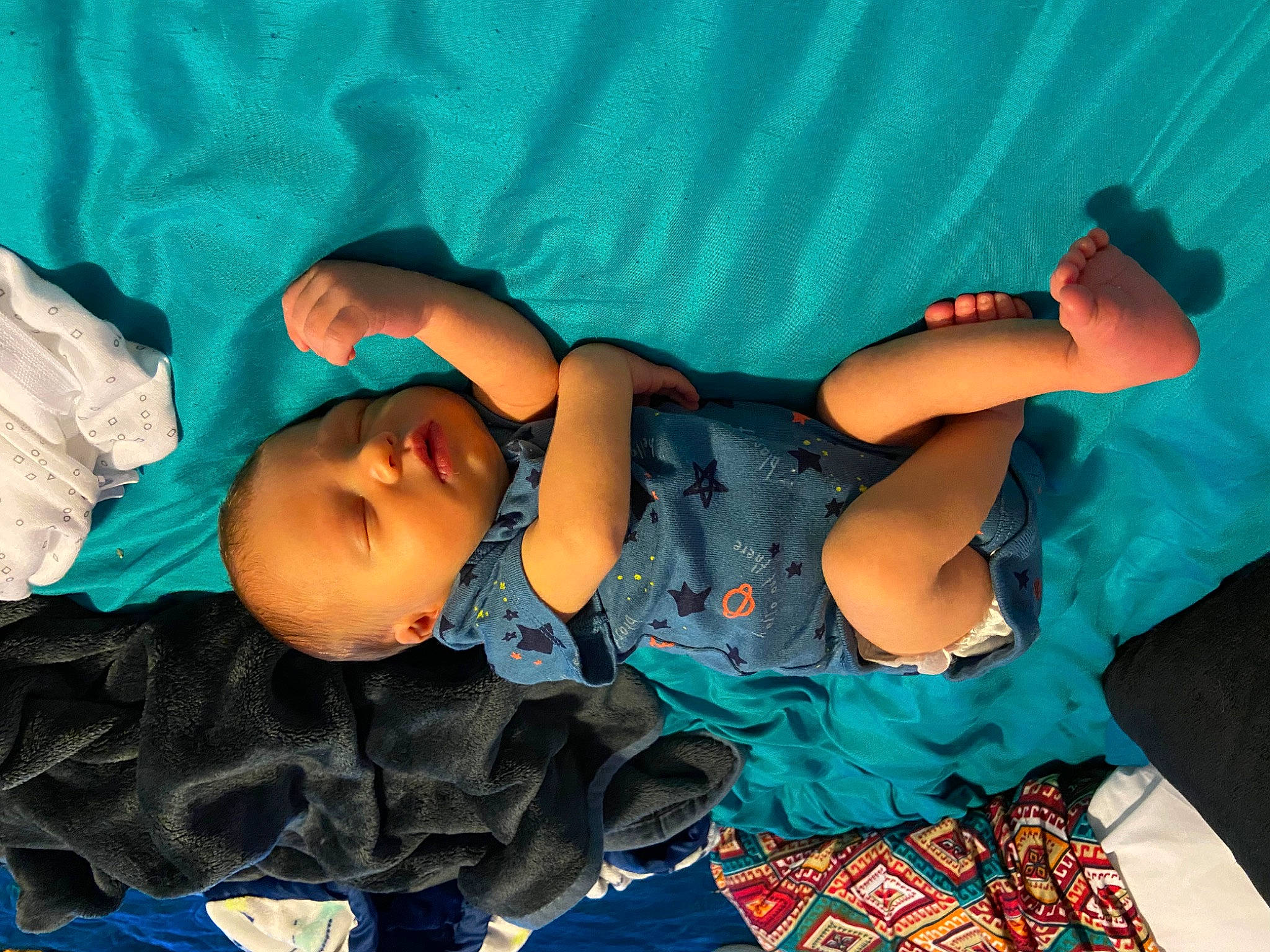 Alistair is registered to the contest to win money with this photo: abdomen, aqua, azure, baby, baby_products, baby_toddler_clothing, black_hair, child, comfort, electric_blue, fun, happy, human_body, human_leg, pattern, person, sitting, smile, thigh, toddler