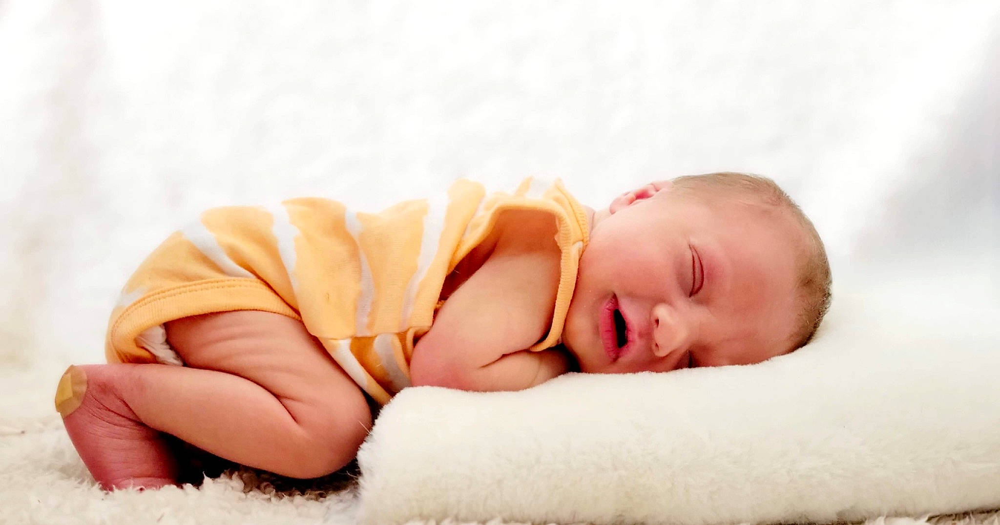 Alistair is registered to the contest to win money with this photo: arm, baby, baby_sleeping, baby_toddler_clothing, comfort, eye, face, finger, flash_photography, flooring, foot, head, headgear, human_body, human_leg, linens, person, sitting, sleeve, toddler