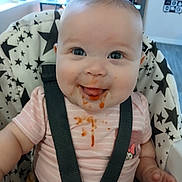 Evelyn joined the competition — help win amazing prizes! baby, high_chair, food_mess, smiling, face, child, straps, clothing, indoor, seat, star_pattern, happy, infant, tongue_out, messy, cute, person, young_child, casual, portrait