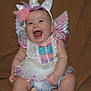 Evelyn is registered to the contest to win money with this photo: baby, infant, unicorn_costume, laughing, happy, wings, horn, pink, purple, blue, white, dress, sitting, cute, chubby, smile, child, portrait, indoor, costume