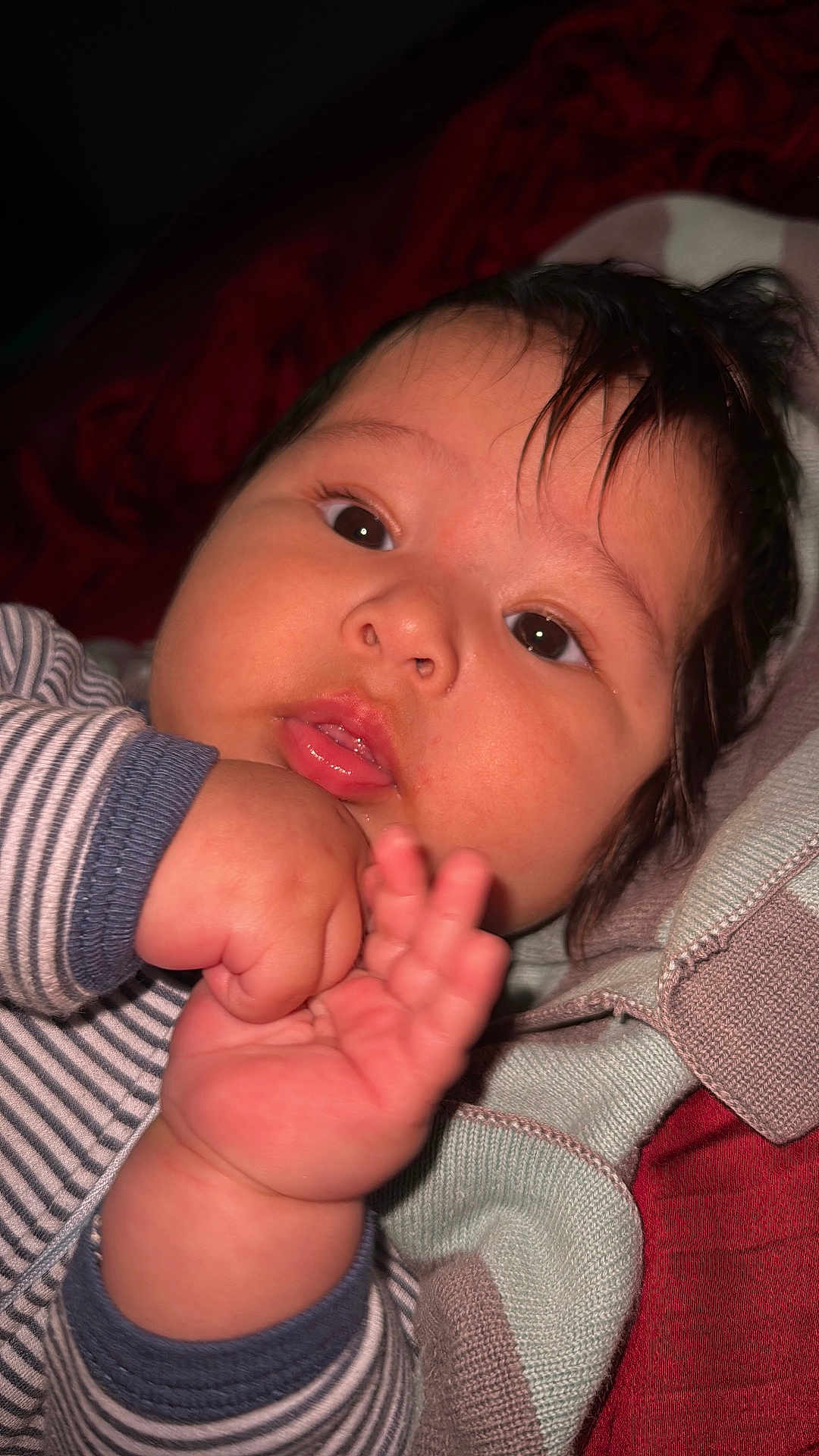 Liam Isaac is registered to the contest to win money with this photo: baby, infant, face, hand, eyes, mouth, striped_clothing, blanket, close_up, cute, chubby, skin, person, young_child, portrait, indoors, soft_lighting, expression, curious, cozy