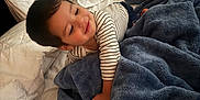 Andre Ariel is registered to the contest to win money with this photo: toddler, child, bed, blanket, pillow, white, blue, striped_shirt, sleepwear, smile, indoors, cozy, soft_texture, nursing_pillow, rest, comfort, portrait, young_child, happy, cute