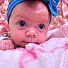 baby, infant, child, portrait, face, blue_bow, headband, pink_blanket, pink_background, wide_eyes, looking_at_camera, lying_down, cozy, soft_texture, nursery, indoor, close_up, adorable, fashion_accessory, photography