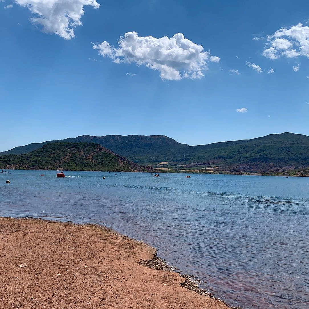 Malou a rejoint le concours — aidez-le/la à gagner de superbes lots ! azure, bank, beach, cloud, coastal_and_oceanic_landforms, cumulus, highland, hill, horizon, lake, landscape, mountain, mountain_range, mountainous_landforms, natural_landscape, sky, tree, water, waterway, wind_wave