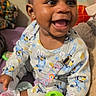 Ohana joined the competition — help win amazing prizes! baby, child, smiling, toy, pajamas, indoor, bed, happy, cute, infant, person, sitting, colorful, playful, face, hand, sock, furniture, room, young