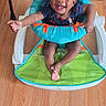 Ohana is registered to the contest to win money with this photo: baby, smiling, child, baby_seat, floor, wooden_floor, indoor, happy, person, infant, seat, clothing, footwear, toy, colorful, cute, small_child, furniture, room, playful