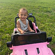 Harper joined the competition — help win amazing prizes! casual_clothing, child, cute, daylight, fun, grass, greenery, happy, nature, outdoor, person, pink, playtime, small_vehicle, smiling, summer, sunlight, toddler, toy_car, vehicle