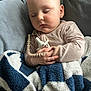 Louis is registered to the contest to win money with this photo: baby, blanket, child, comfort, couch, cozy, face, hand, head, indoor, infant, naptime, pacifier, peaceful, person, relaxation, rest, sleeping, soft_texture, striped_clothing