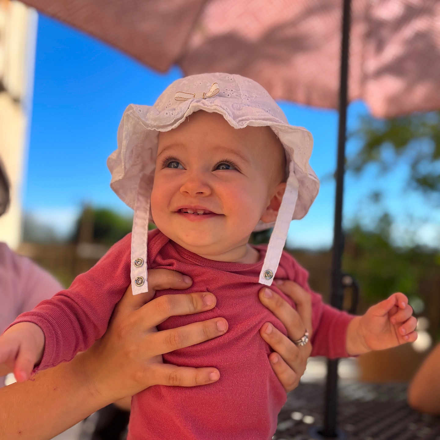 Amaya participe au concours pour gagner de l'argent avec cette photo : baby, blue_sky, child, cute, daylight, hands, happy, holding, infant, nature, outdoor, person, pink_outfit, portrait, smiling, summer, sunlight, table, umbrella, white_hat